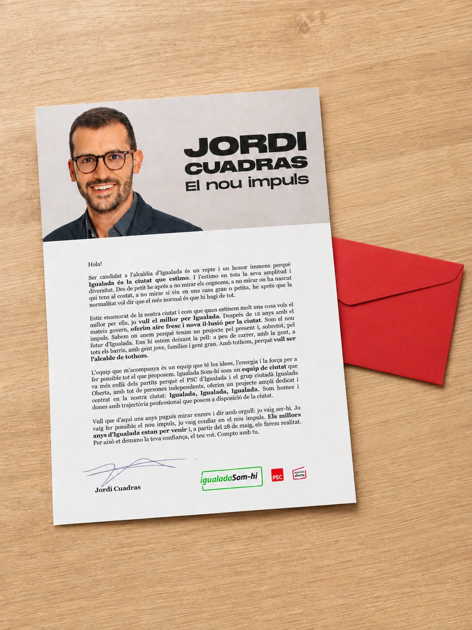 Campaign letter beside a red envelope on a wooden table.
