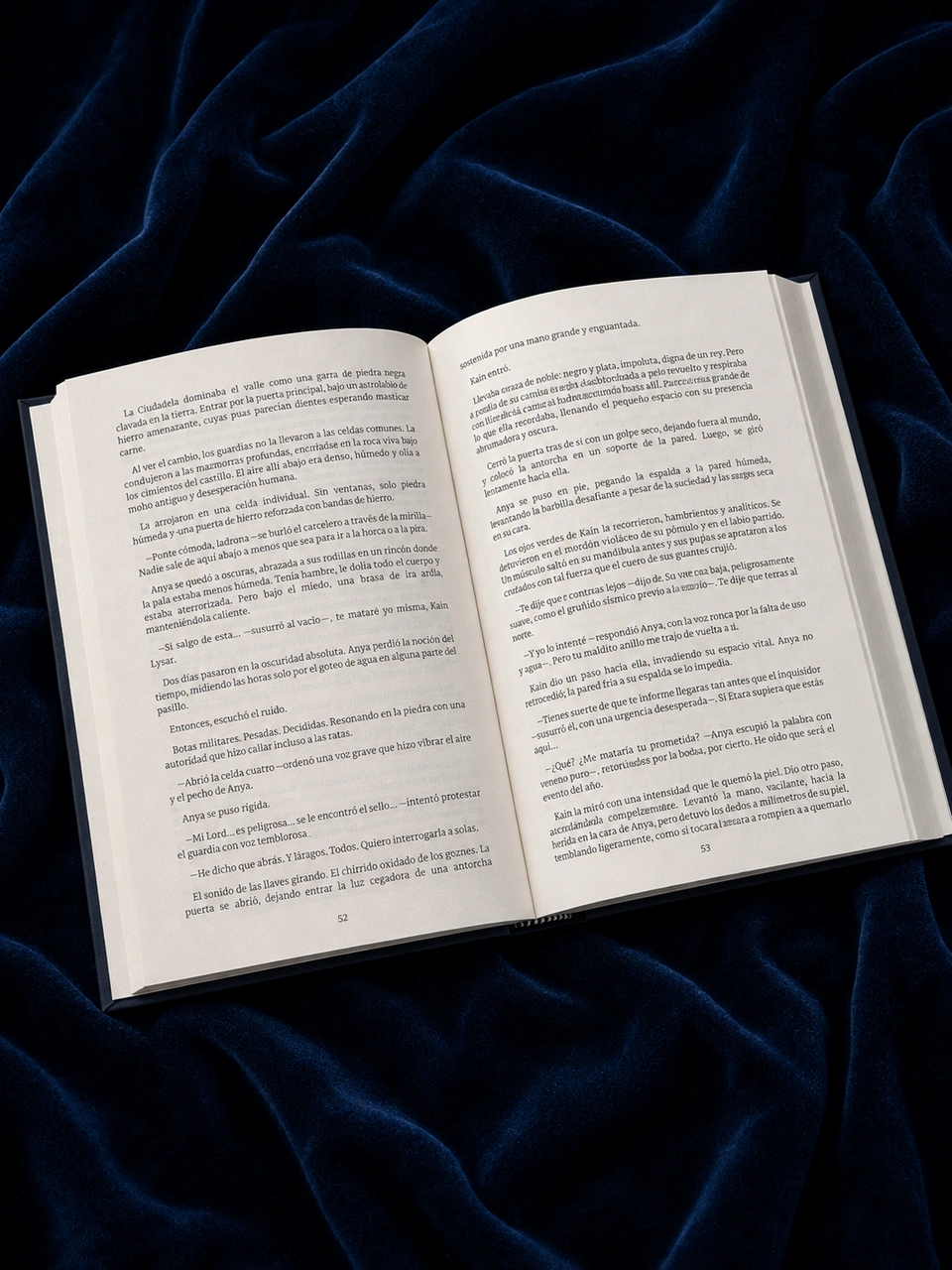 Susurros de Hielo open to an interior spread on dark blue velvet, showing the serif typography and page layout.