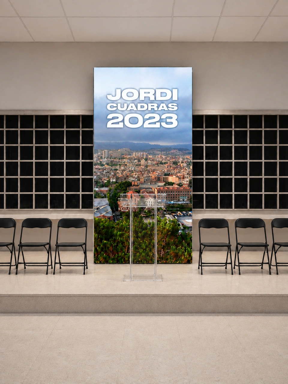 Frontal stage mockup with a Jordi Cuadras 2023 LED screen, black folding chairs and a transparent lectern.