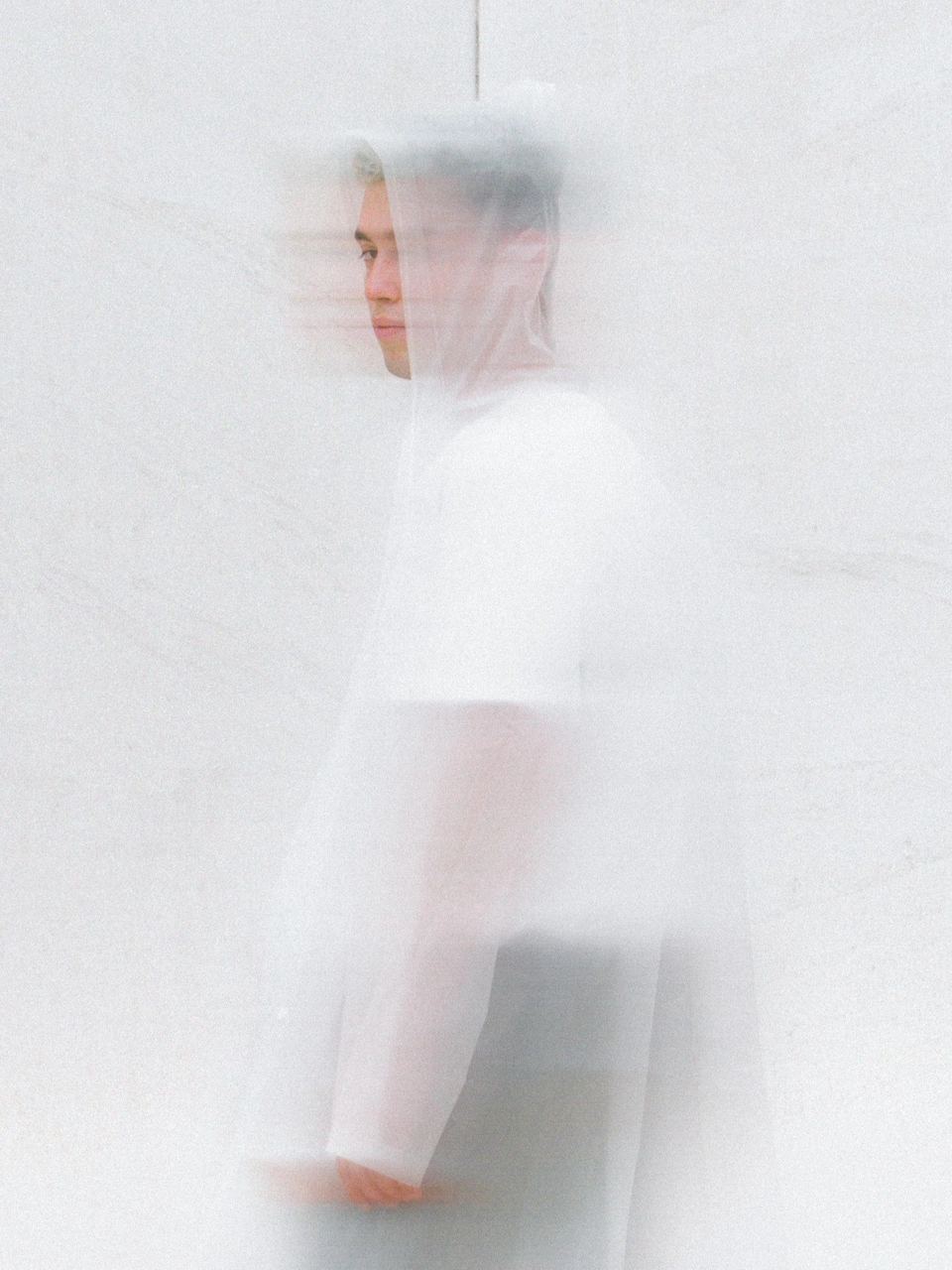 Layered portrait of Víctor Recio Rodríguez moving behind translucent white fabric.